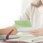 インフレに勝つ不動産投資はどれ？と J-REIT・実物不動産・クラファンの違いを比較する女性の背景画像